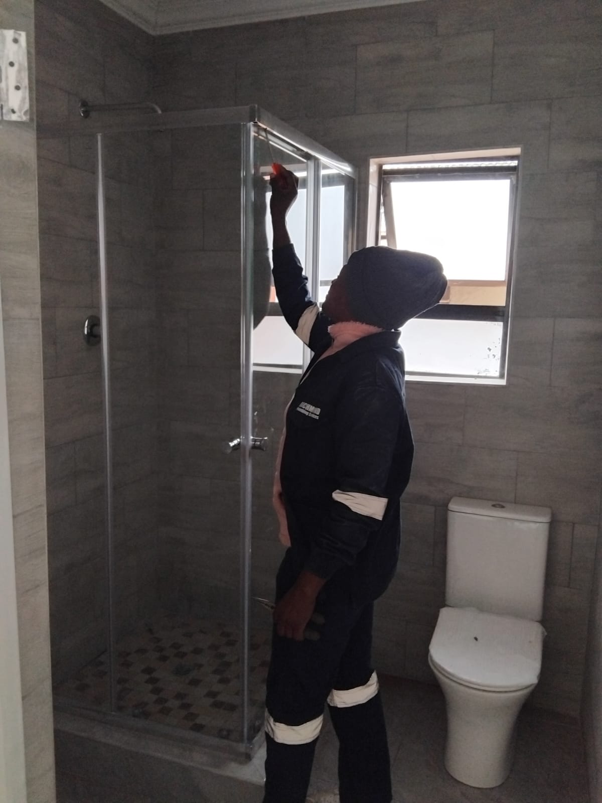 Plumber inspecting a shower enclosure installation